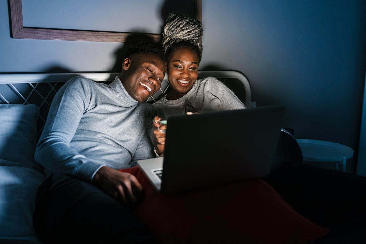 Couple watching a video while on the couch.