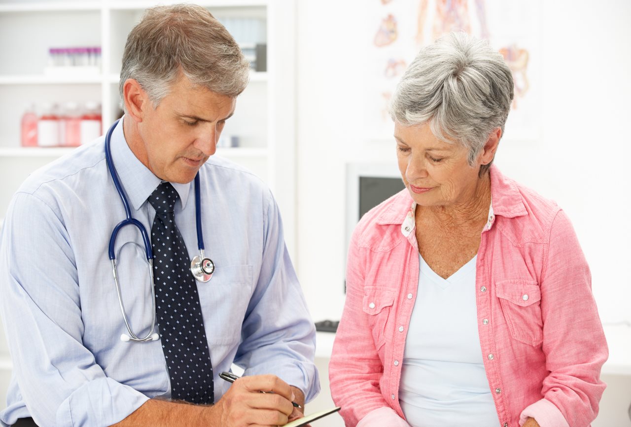 Doctor writing a prescription for a patient.