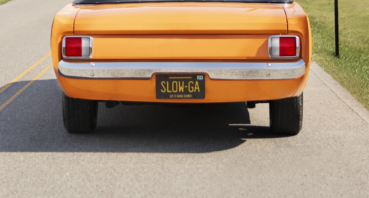 Yellow convertable with rear license plate that says