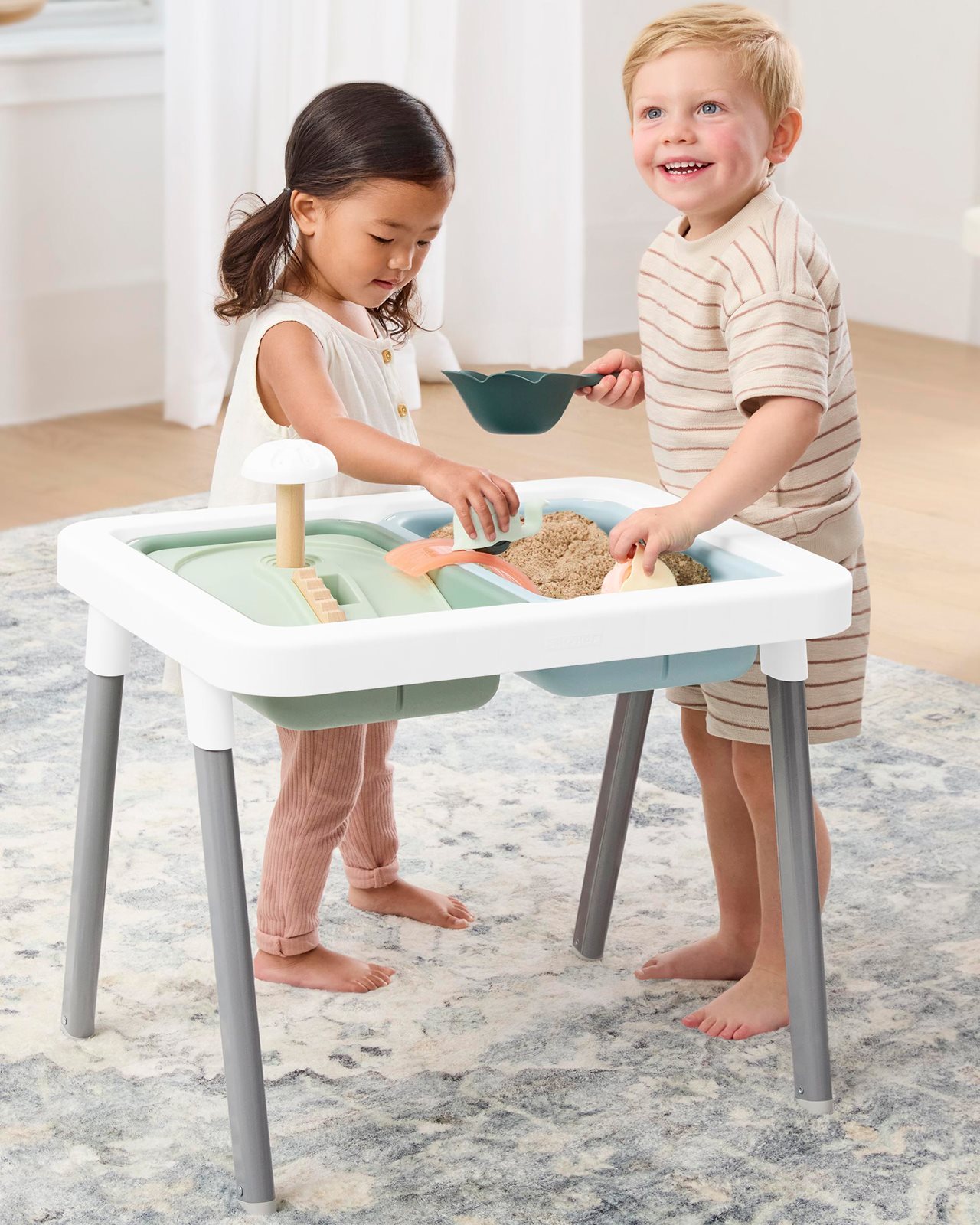 Little boy and girl playing at toddler sensory table.