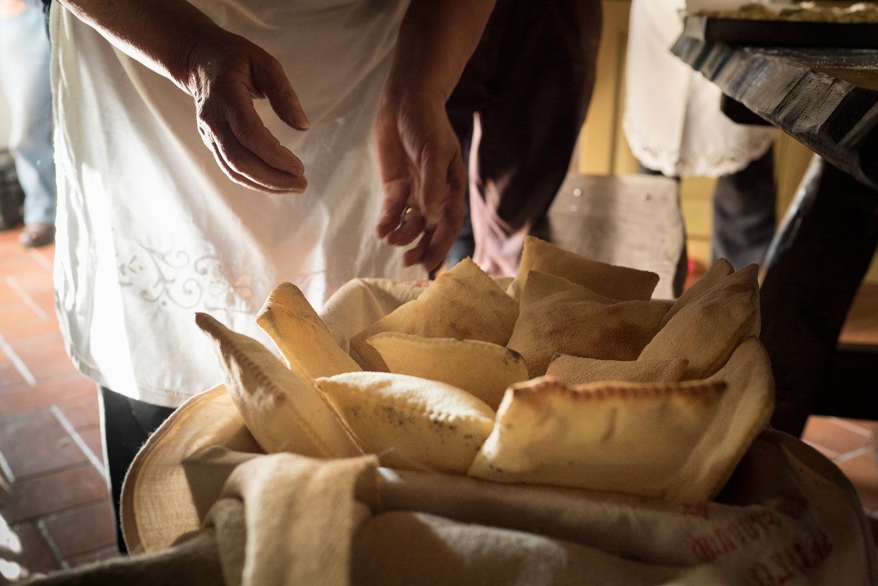 Baker working with traditional ingredients in a rustic venue.