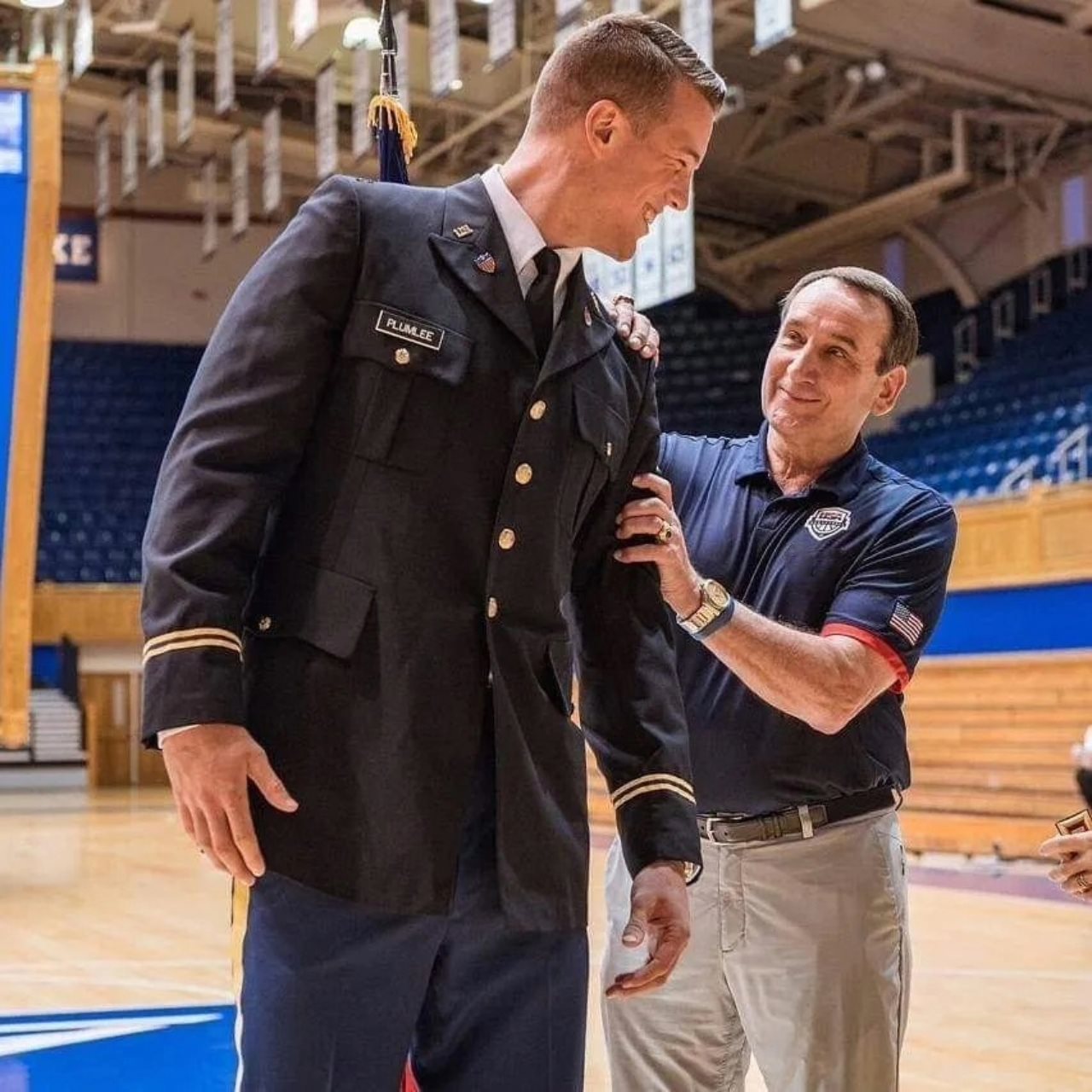 Marshall Plumlee in military uniform and coach K together on a basketball court.