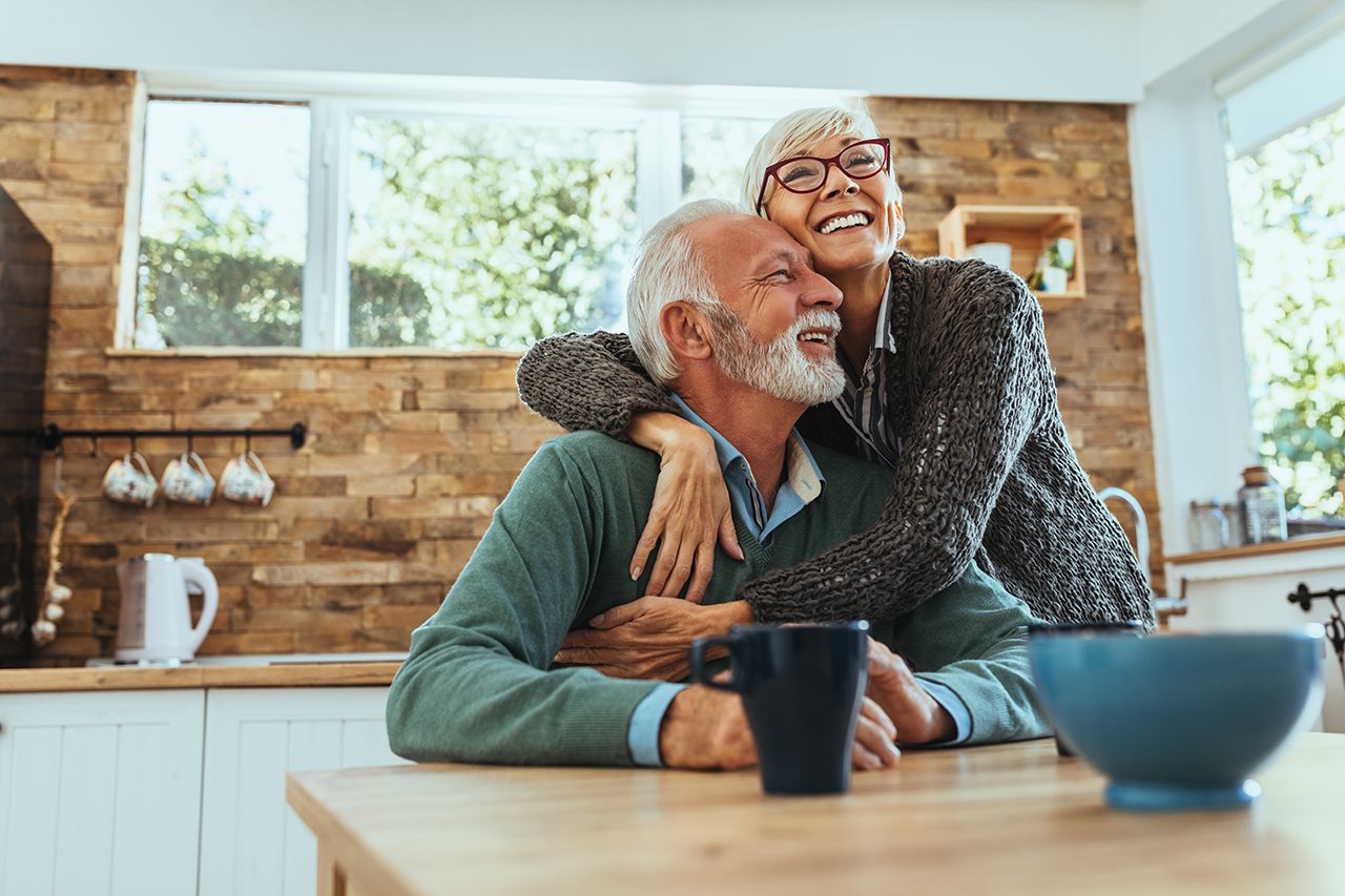 Happy older couple hugging in the kitchen