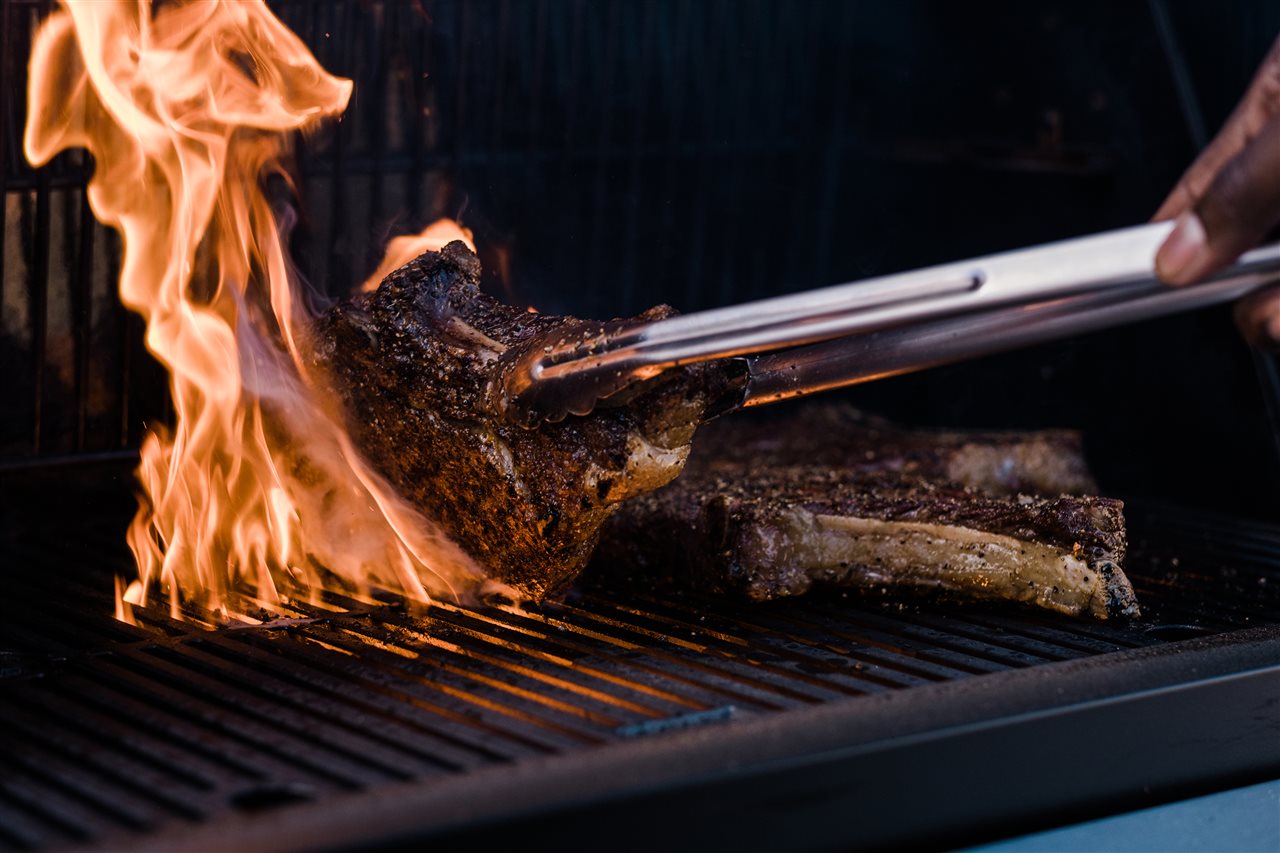 Man grilling beef on a Mastergrill grill.