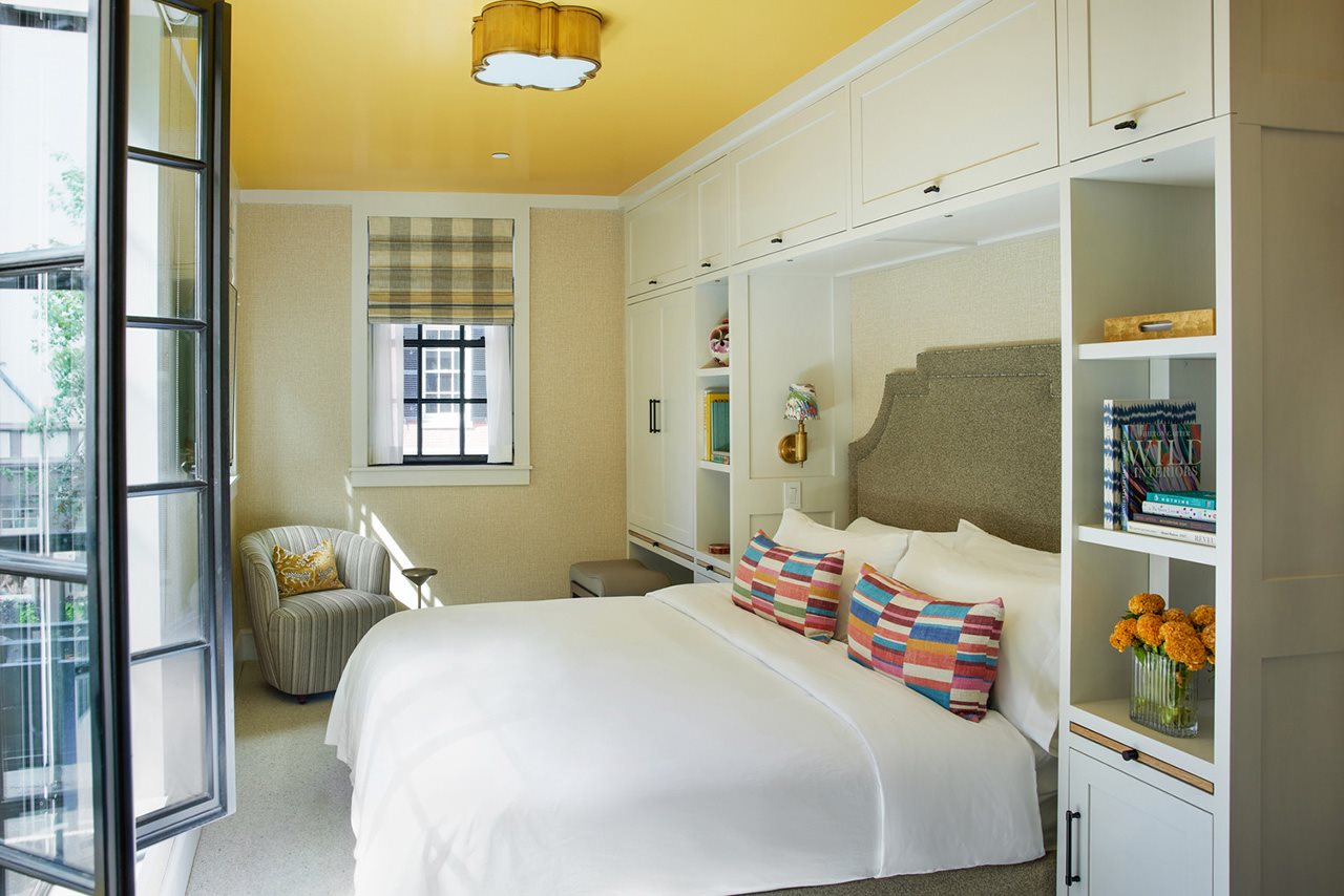 A hotel room with white and yellow furnishings at Beacon Hill