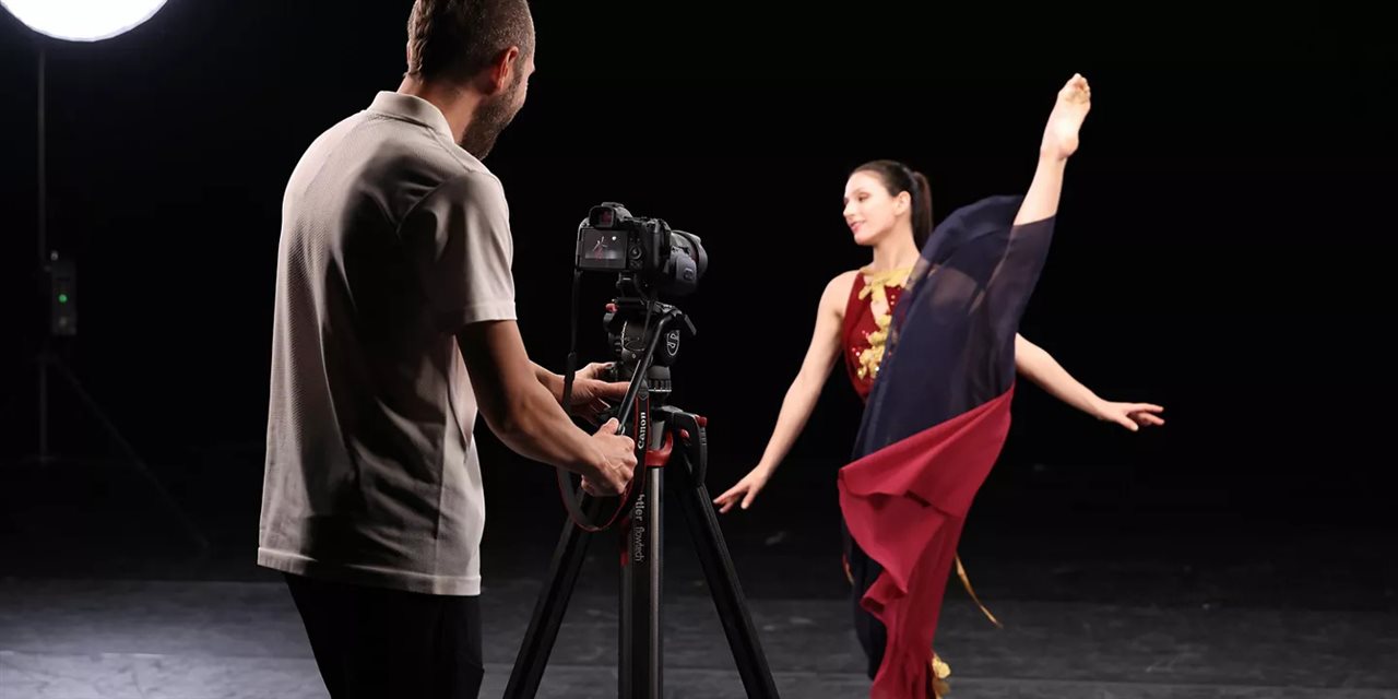 Photographer tkaing a picutre of a dancer with a Canon camera.