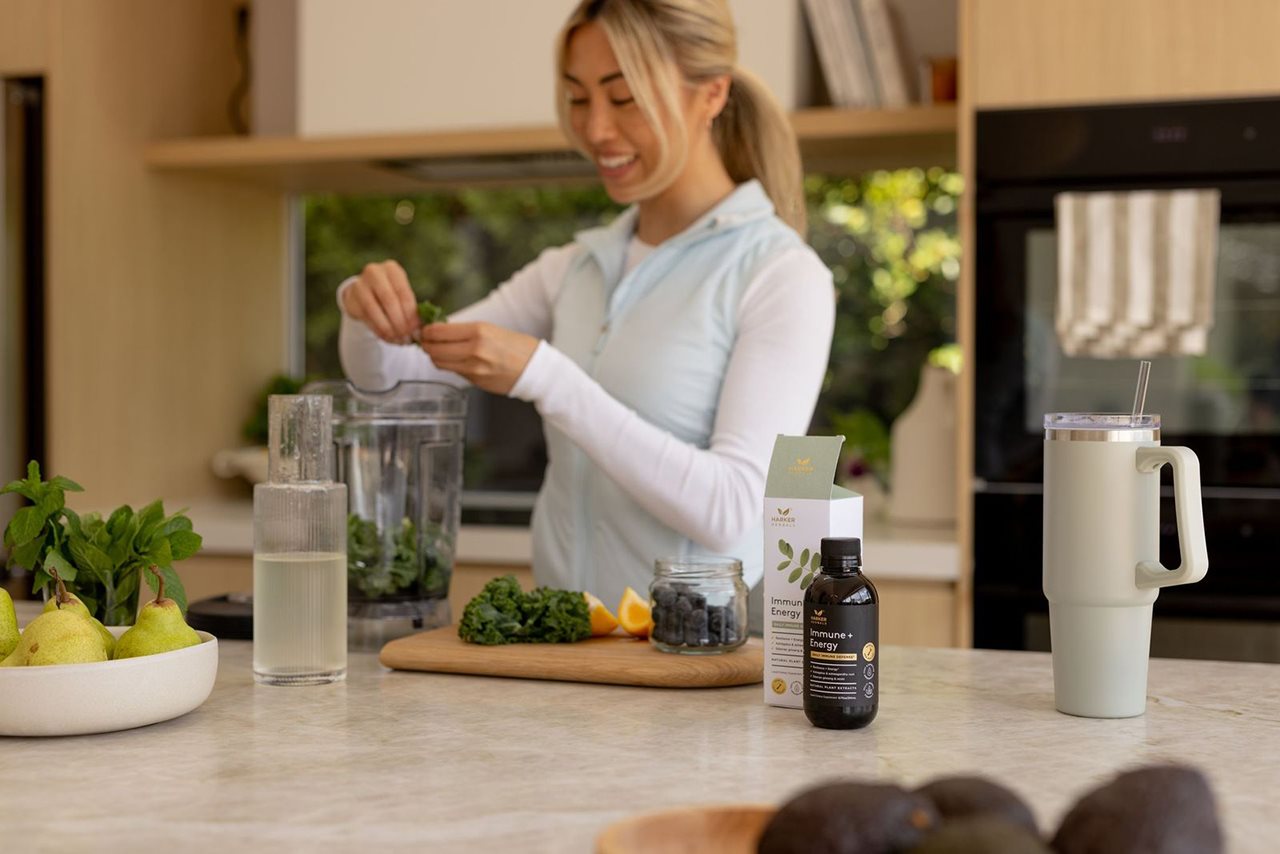Woman preparing a smoothy with a Harker Herbals supplement for immune + energy.