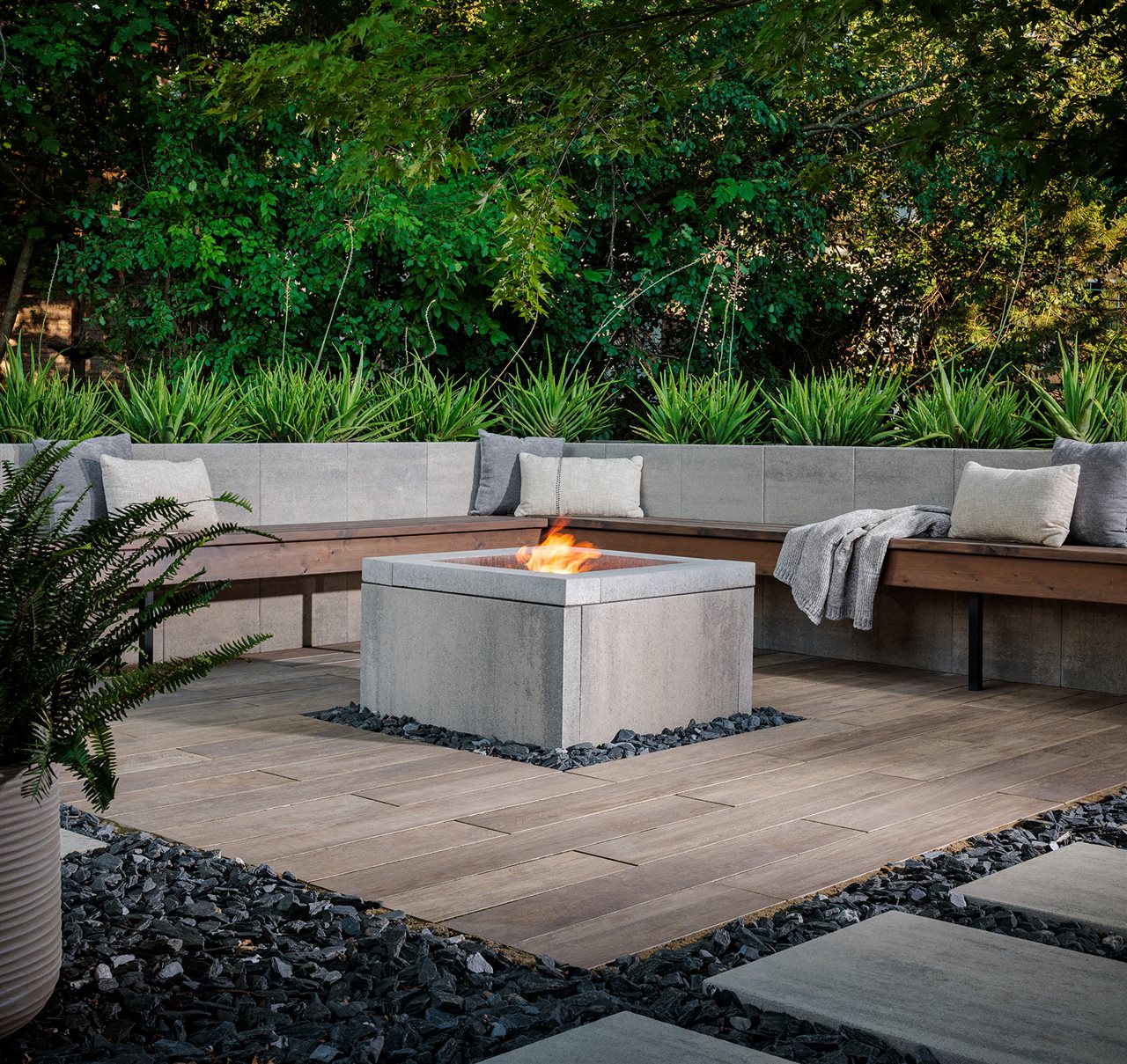 Backyard with landscaped patio and built-in seating and fire feature.