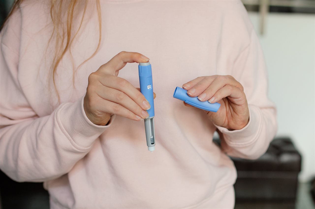 Person holding an injection device.
