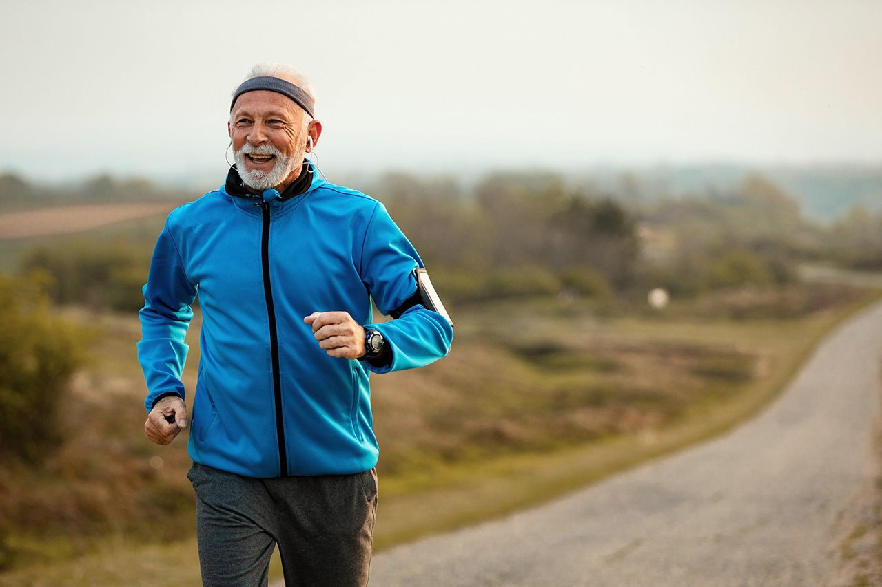 Senior man jogging down a country road. Finding cancer early may help increase the chances of treating and potentially surviving cancer.