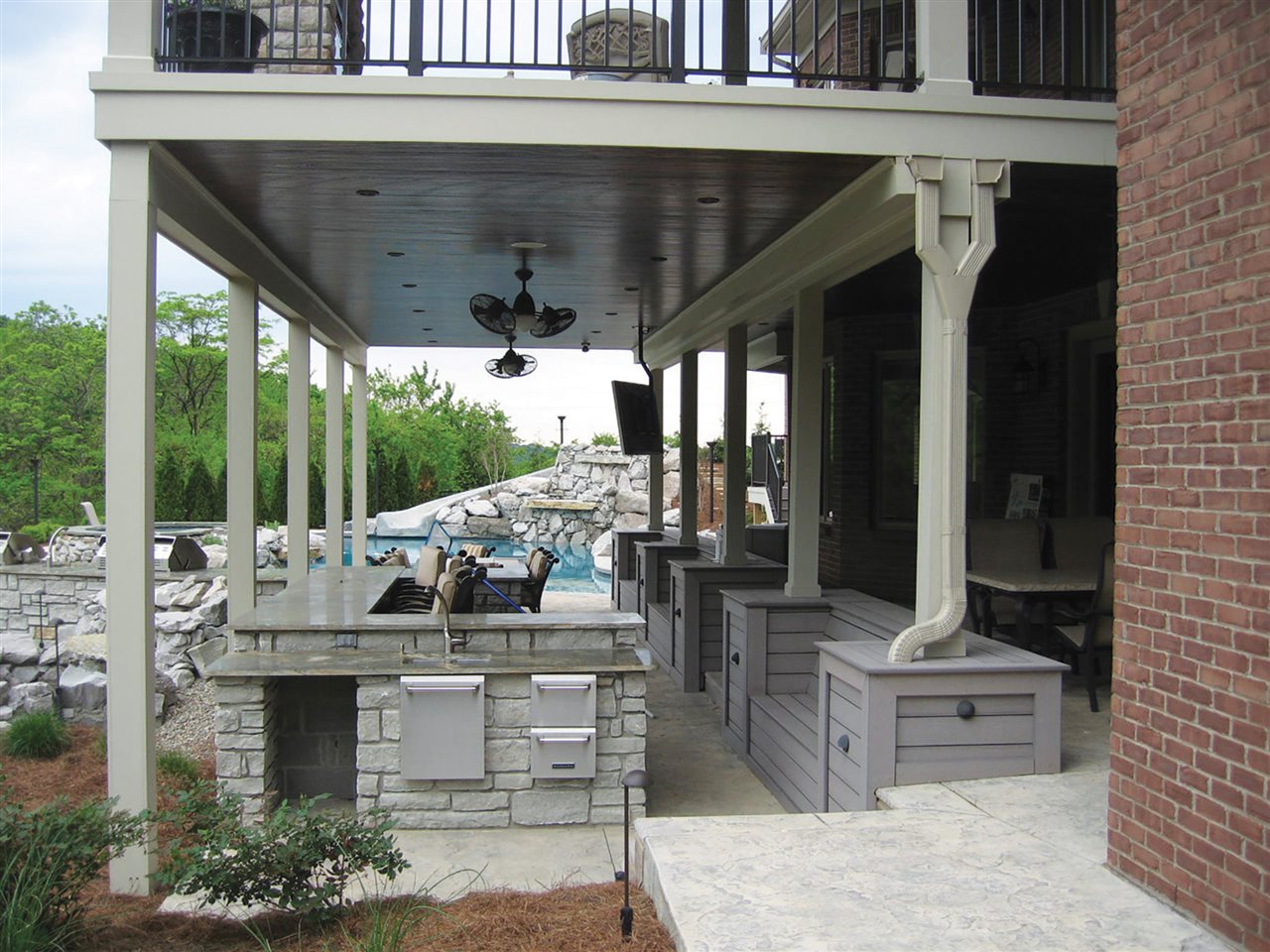 A deck with an outdoor kitchen under a walkout patio.