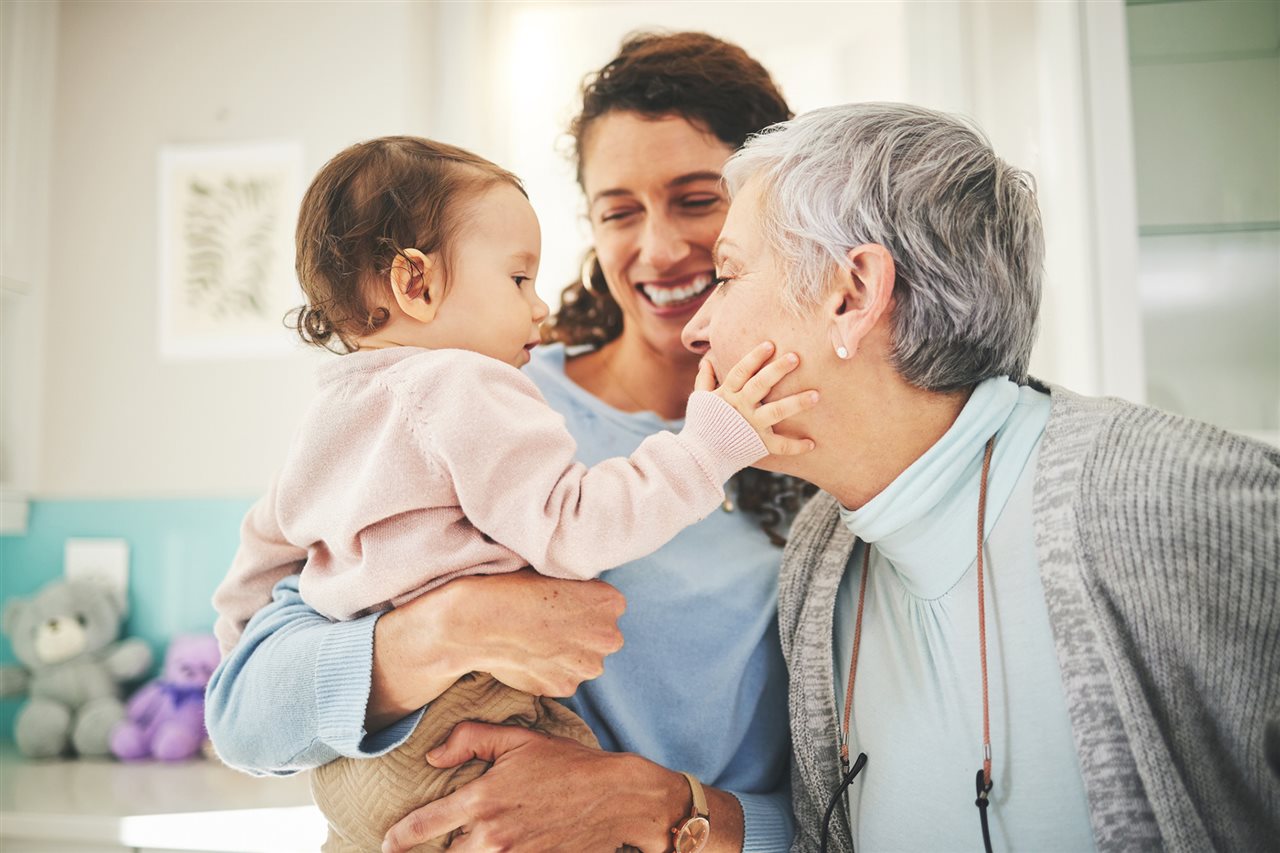 Female caregiver with her mother and baby at home.