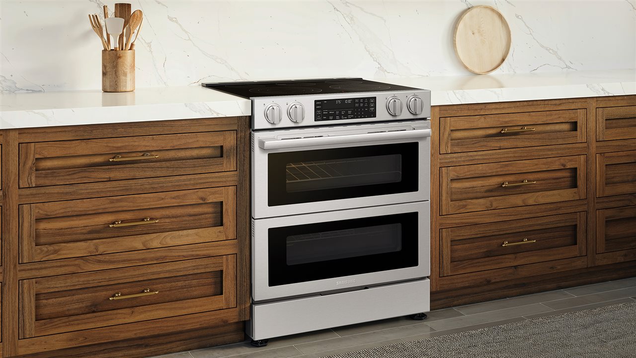 The Samsung Bespoke Over-the-Range Microwave with DualVent Technology NSE90H63S Electric Range in the kitchen.